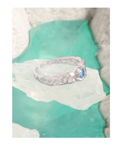 Detailed macro of S925 silver ring with irregular texture and blue zircon stone