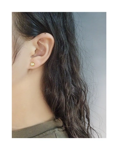 Close-up of minimalist gold S925 silver stud earring with zircon on model's ear