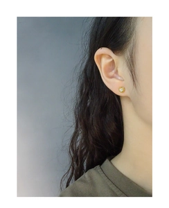 Detailed close-up of a mini gold S925 silver stud earring with a round clear zircon on ear