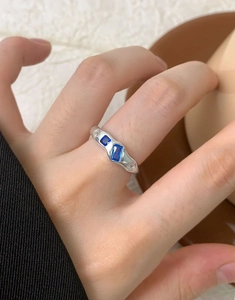 Detailed macro view of S925 silver ring featuring blue zircons on a wavy metal band