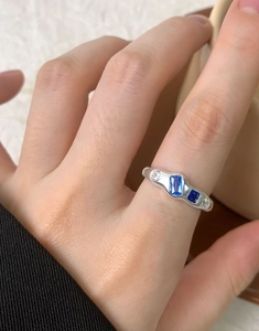 Macro detail of geometric silver ring with blue rectangle zircon and crystal stones
