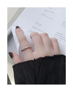 Detailed view of S925 silver ring with irregular lava texture on index finger