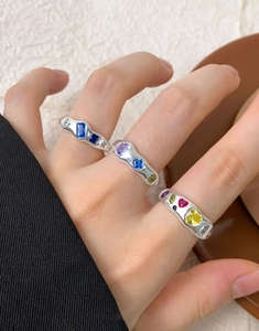 Close-up of S925 silver rings with colorful zircon stones and wavy textures