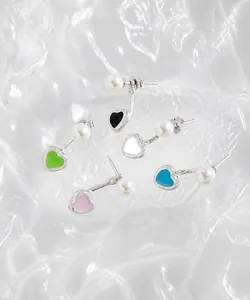Vue détaillée de boucles d'oreilles cœur en émail coloré avec perles sur fond glacé
