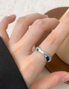 Close-up of S925 silver ring with embedded green round and blue rectangular zircon gems