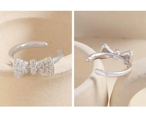 Macro detail of S925 sterling silver bow ear cuff with micro-paved sparkling zircon stones