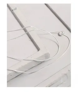 Macro detail of silver S925 double-layer snake chain necklace with a minimalist ring pendant