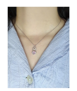 Detailed view of pink heart zircon pendant on a silver pin link necklace worn by a model