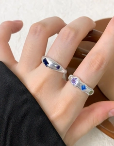 Detail of silver lava-style rings with colorful cubic zirconia on a model's hand