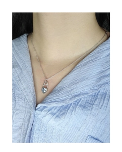 Close-up of a heart-shaped light blue zircon necklace on a model with silver chain