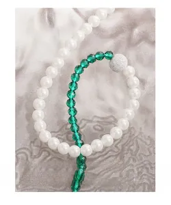 Macro detail of green sandstone beads and white pearls on an asymmetric S925 silver necklace