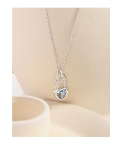 Macro detail of S925 silver necklace with heart-shaped light blue gemstone and rope texture