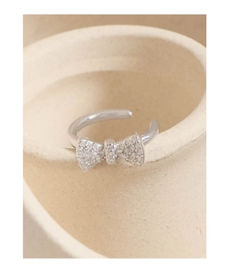 Detailed macro shot of a bow-knot S925 silver ring featuring cubic zirconia accents