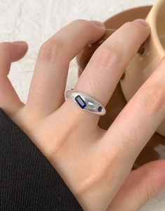 Macro shot of silver ring featuring rectangle and round blue zircon stone inlay