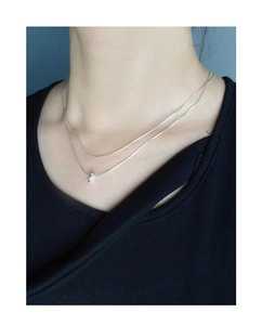 Detail of layered S925 sterling silver snake bone chain necklace on female model