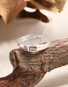 Detail of S925 sterling silver stamp on adjustable ring with three colored stones