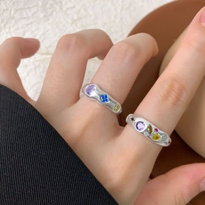 Irregular S925 silver rings with colorful zircon inlays worn on a hand against neutral background