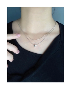 Close-up of minimalist double-layer S925 silver necklace with oval bead on snake chain