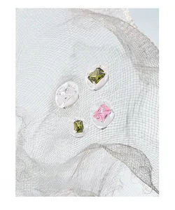 Close-up of rectangular gemstone stud earrings in pink and green with silver S925 settings