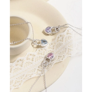 S925 silver heart necklaces with zircon in purple, blue, and pink on a lace dish