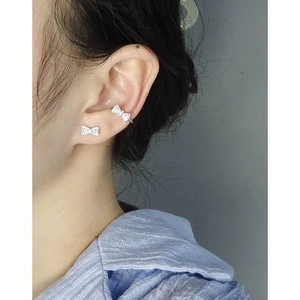 Elegant S925 silver bow stud earrings with zircon stones worn on model's ear