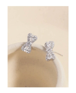 Macro view of S925 silver bow stud earrings with pear-shaped and pavé cubic zirconia