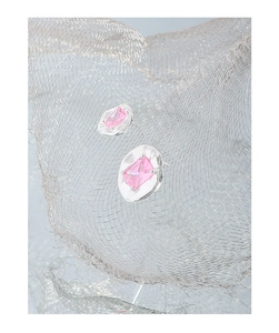 Macro detail of S925 silver stud earring with pink zircon on irregular textured base