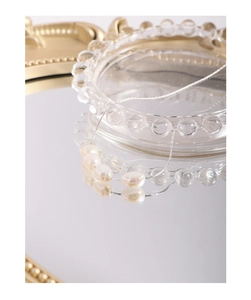 Artistic close-up of baroque pearl necklace with silver chain on mirror and glass background