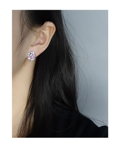 Detail of S925 silver stud earring with liquid metal texture and pink zircon stone
