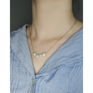 Minimalist S925 gold necklace featuring four natural baroque pearls worn by a model