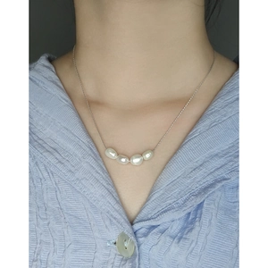 Minimalist S925 silver necklace with four natural baroque pearls worn by a model