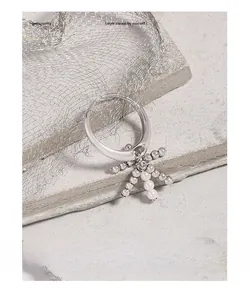 Macro view of S925 silver ring featuring an insect-shaped pendant with white pearls