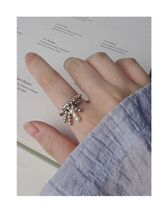 Detailed shot of a silver S925 beaded ring with hanging pearls on a hand model