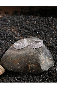 Macro shot of silver cube earrings with micro-set zircons on dark stone background