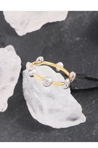 Detailed shot of two-tone open ring featuring textured silver beans on a gold band