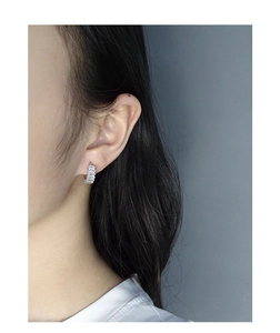Close-up of S925 silver C-shape earrings featuring baguette-cut zircon inlay on a model