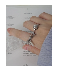 Detail of S925 silver ring featuring a large metal sphere and a pearl tassel charm