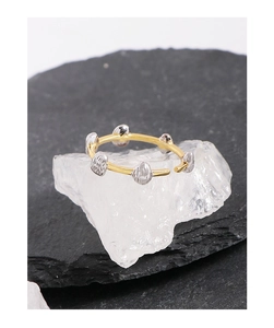 Macro shot of minimalist gold thin band ring featuring irregular silver pebble accents