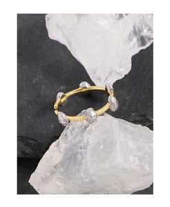 Close-up of S925 sterling silver stamp and metallic bean design on a gold open ring