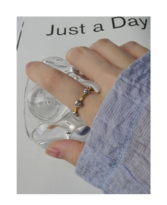 Detail of S925 silver two-tone open ring with metallic beads on a gold band