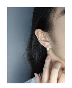 Close-up of minimalist S925 silver hoop earrings with baguette-cut zircon inlay