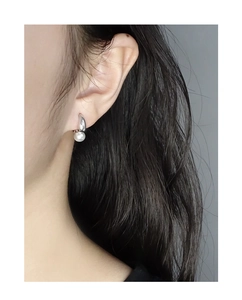 Close-up of elegant S925 sterling silver geometric earring with a round white pearl on ear