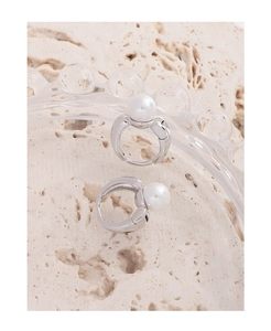Detailed view of polished S925 sterling silver hoop earrings with round white pearls