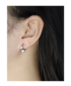 Detail view of a minimalist S925 silver pearl drop earring on model with smooth metal finish