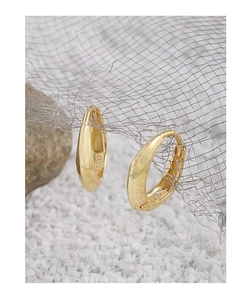 Detailed close-up of S925 sterling silver stamp on golden irregular huggie earrings