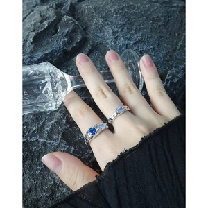 S925 silver ring set with blue zircon and moonstone on a textured dark rock background