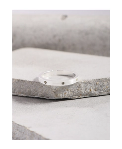 Macro detail of S925 silver ring with brushed matte finish and three small zircons