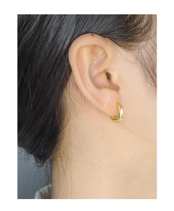 Close-up of minimalist irregular gold hoop earrings worn by a model for a chic look