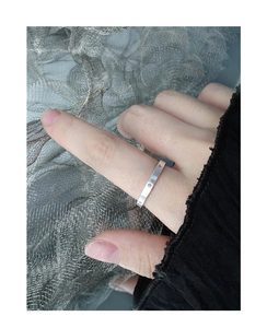 Close-up of minimalist S925 silver ring with brushed texture and zircon on finger