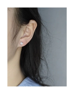Gros plan d'une boucle d'oreille cœur en argent S925 avec zircone sur le lobe
